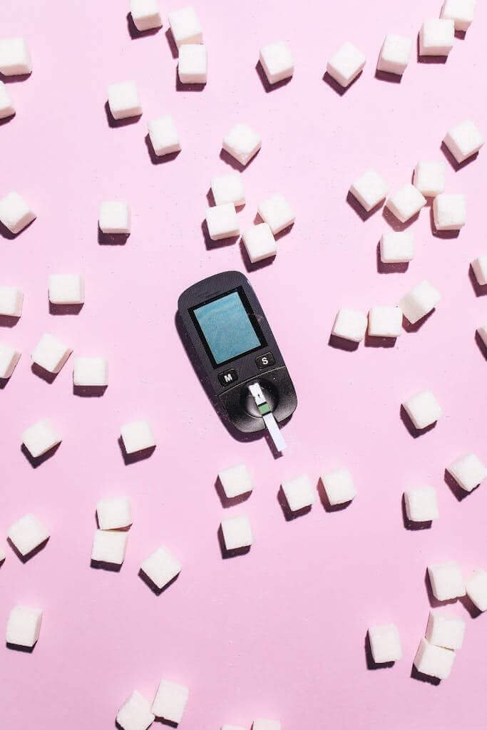 Glucometer Lying Among Scattered Sugar Cubes 